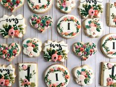 decorated cookies arranged in the shape of hearts and flowers on a white table with floral decorations