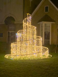 a lighted christmas tree in front of a house