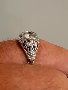 A wonderful Victorian band with great filigree detail. The center stone measures out at .80 ct and has a clarity of SI1 and G color. There is a small natural crystal on the girdle. On either side are 2 @.05ct diamonds set in diamond shape gold. The band weighs 2.5 grams and is is excellent condition. It measures 8.5mm across the top. Antique Diamond Ring With Prong Setting, Antique Round Diamond Ring With Single Cut Diamonds, Antique Round Diamond Ring, Diamond White Oval Filigree Jewelry, Heirloom Platinum Jewelry For Marriage, Antique White Diamond Filigree Ring, Vintage Round Cut Diamond Jewelry, Heirloom Diamond Cut Round Jewelry, Oval Diamond Filigree Jewelry