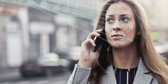 a woman talking on a cell phone while holding her hand up to her ear and looking at the camera