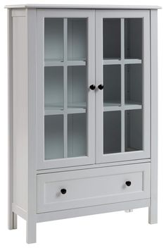 a white cabinet with glass doors and drawers