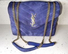 Description & Condition: 100% Authentic YSL Blue Small Suede Loulou Bag This chic bag is crafted of blue quilted suede calf-skin leather exterior in a chevron pattern, and brass hardware and straps. The envelope-style flap has a magnetic closure and opens to blue grosgrain leather lining with two spacious compartments separated by a zipper pocket. This gorgeous bag is perfect for daily use or a special occasion! Size: 9” wide; 6.5” high; 3.5” deep; 12-22” strap drop, able to be worn on the shoulder or crossbody. Included: no items Date code: GAS494699-0820 - Made in Italy in 2020. This has been professionally authenticated by Dr. Runway. VERY GOOD preloved condition. The exterior suede is in good condition with gentle wear and marks. The hardware is in excellent condition. The interior lin Blue Saint Laurent Bag, Ysl Saint Laurent, Blue Chevron, Chic Bags, Gorgeous Bags, Chevron Pattern, Brass Hardware, Magnetic Closure, Yves Saint Laurent