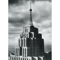 a black and white photo of the top of a building with a radio tower in the background