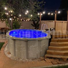 an above ground swimming pool with steps leading up to it and lights strung from the ceiling