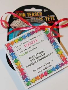 a piece of puzzle themed business card with a red ribbon tied around the front and back