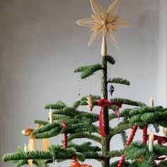 a small christmas tree decorated with candles and ornaments