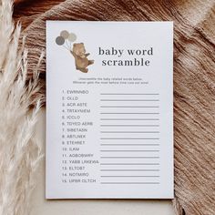 a baby word scramble card with a teddy bear holding balloons on it's back