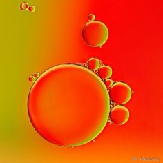 an orange and green background with bubbles in the center, some water droplets on the bottom