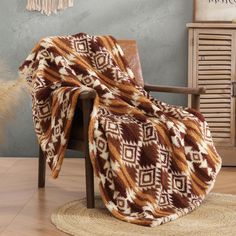 a brown and white blanket sitting on top of a chair next to a wooden table