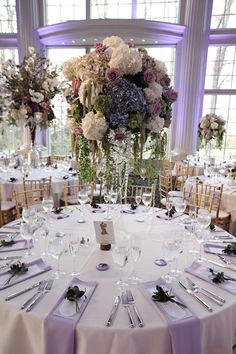 the table is set with white and purple flowers