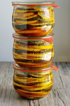 four glass jars filled with food sitting on top of a wooden table