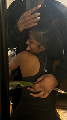 a man is taking a selfie with his daughter in front of a mirror while she sits on the floor