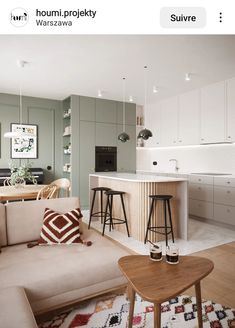 a living room filled with furniture next to a kitchen