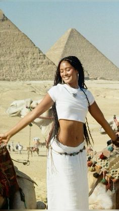 a woman standing in front of the pyramids