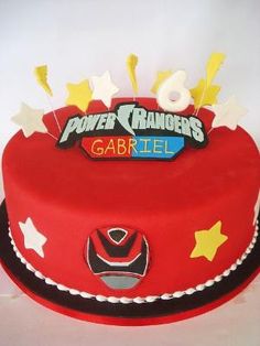 a red cake with white frosting and yellow stars on top that says power rangers gabril