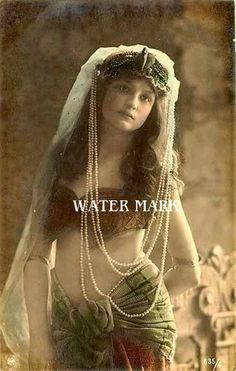 an old fashion photo of a woman with pearls on her head and veil over her face