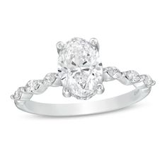 a white gold engagement ring with an oval cut diamond in the center and side stones