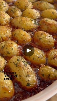 a pan filled with potatoes covered in sauce and garnished with parmesan sprinkles