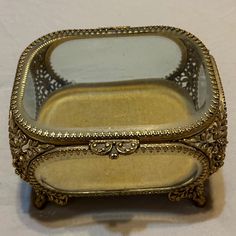 an ornately decorated metal box with glass top