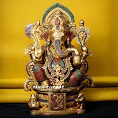 an elephant statue sitting on top of a table next to a yellow wall in front of it