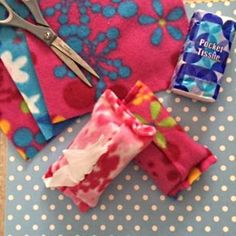 some fabric and scissors are laying on a table with blue polka dot paper napkins