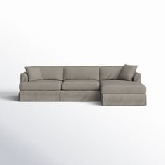 a large sectional couch with pillows on the top and bottom, sitting in front of a white background