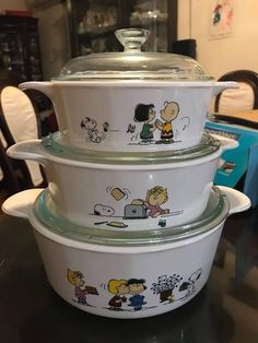 three bowls are stacked on top of each other with cartoon characters painted on the lids