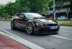 a brown car is driving down the street