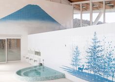 an indoor jacuzzi is shown with blue trees on the wall