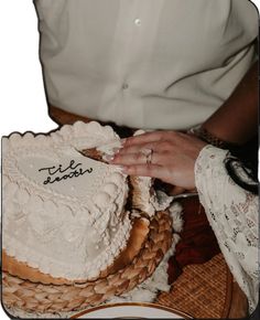 a close up of a person cutting a cake on a plate with the name bride and groom written on it