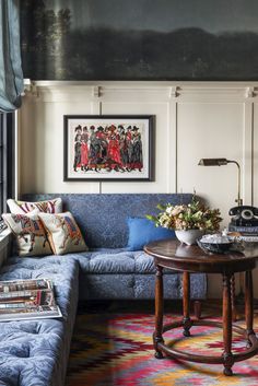 a living room filled with furniture and a painting hanging on the wall over a window