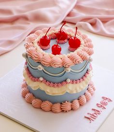 a three layer cake with cherries on top