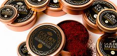 several tins of golden saffron next to each other on a white surface