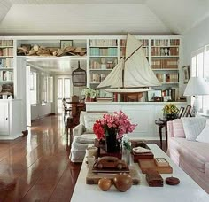 a living room filled with furniture and bookshelves covered in lots of bookcases