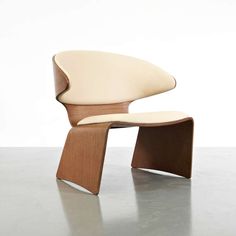 an egg chair with a wooden base and white leather upholstered backrests