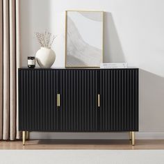 a white vase sitting on top of a black cabinet