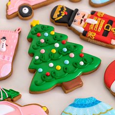 decorated cookies with cars and christmas trees on a white tablecloth covered in icing