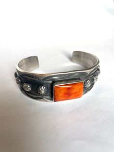 JEWELRY TYPE : Bracelets TRIBAL AFFILIATION : Navajo METAL : Sterling Silver SIGNED? : Signed ARTISAN : Chimney Butte This wonderful Orange Spiny cuff is made by the famous Navajo artist Chimney Butte. This piece has incredible detail work. The cuff is 1 inch wide and the inside circumference is 5 1/2 inches with a gap of 1 1/2 inches. This piece is signed by the artist and Stamped Sterling. Please contact us if you have any questions about this item.Listed 7/22/22 Bohemian Cuff Jewelry For Formal Occasions, Formal Stamped Cuff Jewelry, Adjustable Ceremonial Cuff Jewelry, Classic Adjustable Cuff Bracelet For Ceremonial Occasions, Southwestern Stamped Cuff Jewelry, Cuff, Stamp, The Incredibles, Sterling Silver