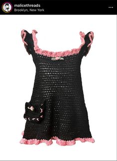 a black dress with pink ruffles and a cat on the front is shown