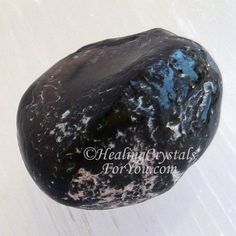 a black rock sitting on top of a white floor