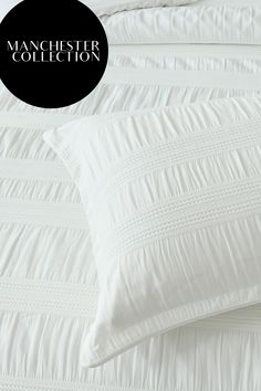 an image of a white comforter and pillows on a bed with the words manchester collection above it