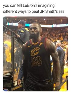 the basketball player is walking down the court with his team's uniform on and people in the stands behind him