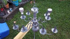 a chandelier made out of an old baseball bat is sitting in the grass