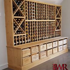 a wooden wine rack filled with lots of bottles next to a wall mounted wine bottle holder