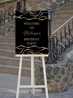 a welcome sign sitting on top of a wooden easel in front of some stairs