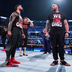 two men standing next to each other on a wrestling ring