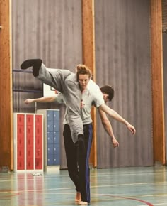 two people doing tricks on a basketball court