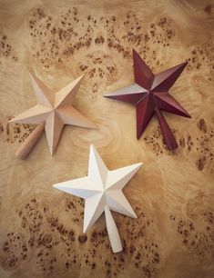 three paper stars on a wooden surface