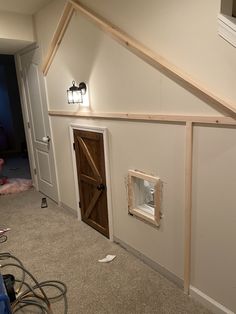 a dog house built into the side of a wall in a room that is being remodeled