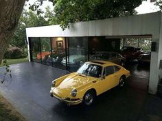 a yellow car parked in front of a garage